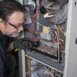 Electrician inspecting a furnace.