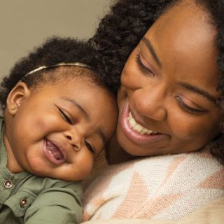 Black mother with giggling child.